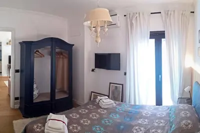 a bedroom with a bed and a mirror and a chandelier at Cozy Suite&Lodge Mondello beach in Palermo