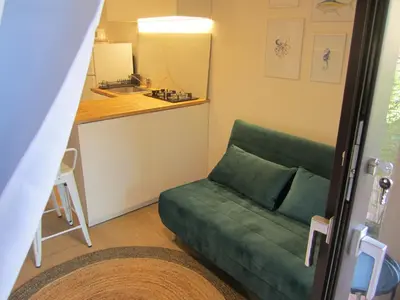 a living room with a green couch and a kitchen at Cozy Suite&Lodge Mondello beach in Palermo