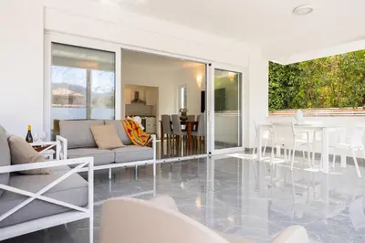 a living room with white furniture and a table at Cube 67 - Garden in Palermo