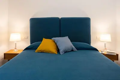 a blue bed with two yellow pillows and two lamps at Cube 67 - Terrace in Palermo