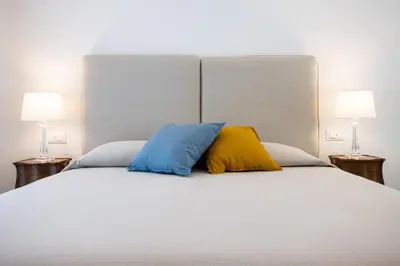 two pillows sitting on top of a bed with two lamps at Cube 67 - Terrace in Palermo