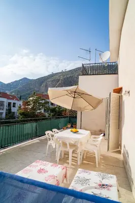 a patio with a table and chairs and an umbrella at A casa di Mara in Mondello