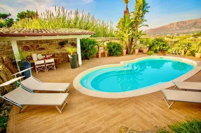 a swimming pool in a yard with chairs and a gazebo at Villa Dorotea con piscina in Trappeto