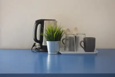 a coffee maker and cups on a blue table at Terrasini 2000 Home Holidays in Terrasini