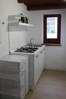 a white kitchen with a stove and a window at Terrasini 2000 Home Holidays in Terrasini