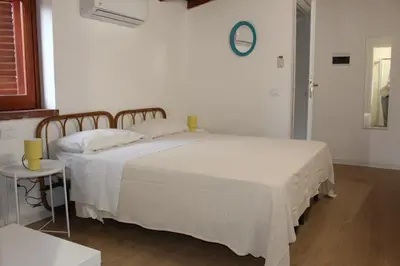 a bedroom with a large white bed and a table at Terrasini 2000 Home Holidays in Terrasini