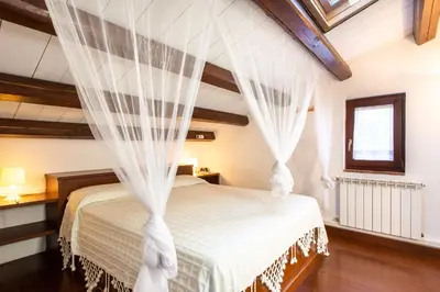 a bedroom with a bed with white curtains at Villetta Rosamarina by Wonderful Italy in Cefalù