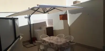 a table and chairs under an umbrella in a room at A Casa Ri Angela in San Vito lo Capo