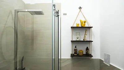 a shower stall in a bathroom with two shelves at Le Maioliche Apartment in Palermo