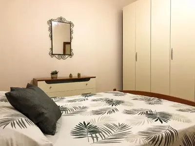 a bedroom with a bed and a mirror at Casa Conchiglia in San Vito lo Capo