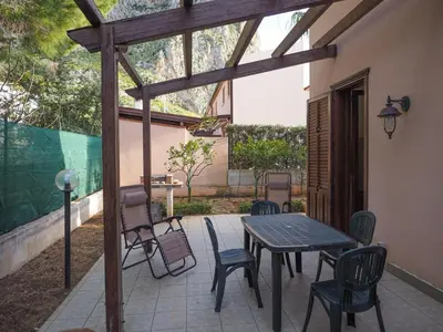 a patio with a wooden table and chairs at Màkari in Macari