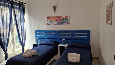 a bedroom with two beds and a blue headboard at Amuri Siculo, Casa Vacanze Palermo centro in Palermo