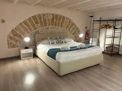 a bedroom with a large bed with a brick wall at Palermo alla Gancia Room in Palermo