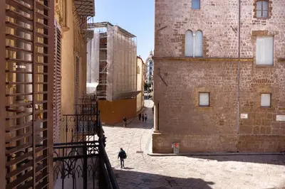 a person walking down a street between two buildings at Aragona15 Suites in Palermo