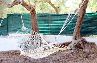 a white hammock hanging between two trees at Violisa Charme in Castellammare del Golfo