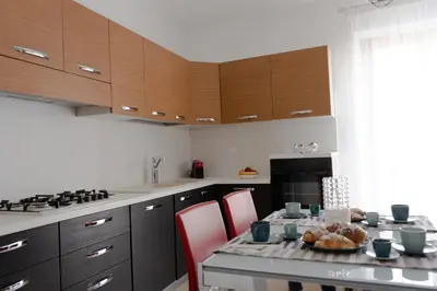 a kitchen with a table with red chairs and a stove at Cassaro Casa Vacanze in Castellammare del Golfo