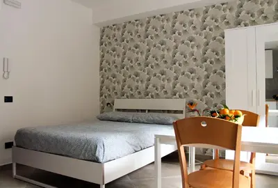 a bedroom with a bed and a table with a dining room at Case Carà 128, Appartamentini nel cuore di Bagheria, Piano Primo in Bagheria
