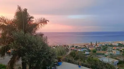 a view of a city and the ocean at sunset at Fronte Mare in Castellammare del Golfo