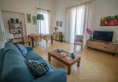 a living room with a blue couch and a table at Le Vele Mondello, villa a due passi dal mare in Mondello