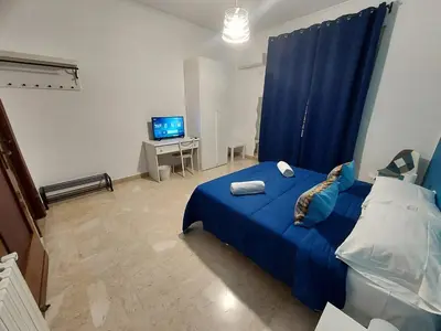a bedroom with a blue bed and a television at La Casa del Moro - Al Politeama in Palermo
