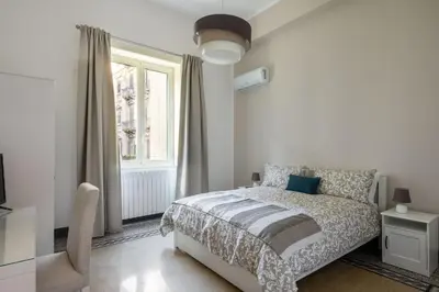 a bedroom with a bed and a desk and a window at Casa Rorro' nei pressi di Via Roma by Wonderful Italy in Palermo