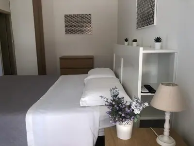 a bedroom with a white bed and a table with a lamp at Dal Porto al Politeama in Palermo