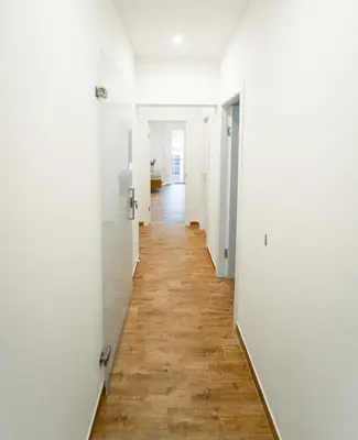 a hallway with white walls and a wooden floor at Civico64 apartments in Castellammare del Golfo