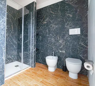 a bathroom with a toilet and a glass shower at Civico64 apartments in Castellammare del Golfo