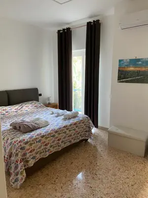 a bedroom with a bed and a window at Villa Savoia Mondello in Mondello