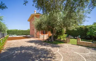 a building with a tree in the middle of a driveway at Beautiful Home In Torre Colonna-Sperone in Mandra Capreria