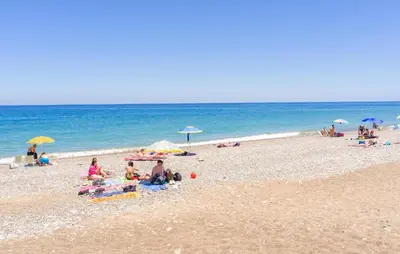 a group of people sitting on a beach with umbrellas at Beautiful Home In Torre Colonna-Sperone in Mandra Capreria