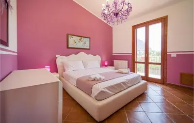 a bedroom with pink walls and a bed with a chandelier at Beautiful Home In Torre Colonna-Sperone in Mandra Capreria