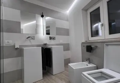 a white bathroom with a sink and a toilet at Le Camere dell’Emiro in Castronuovo di Sicilia