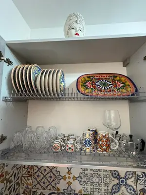 a white wall with a vase with flowers in it at A casa di Francy in Palermo