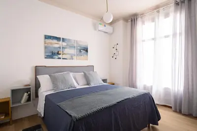 a bedroom with a bed with a blue blanket at La casetta al Politeama in Palermo