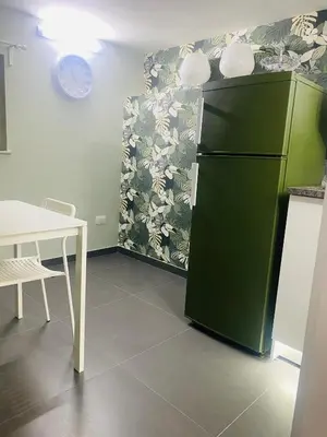 a kitchen with a green refrigerator and a table at Bella Sicilia in Palermo