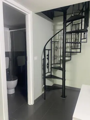 a bathroom with a spiral staircase next to a toilet at Bella Sicilia in Palermo