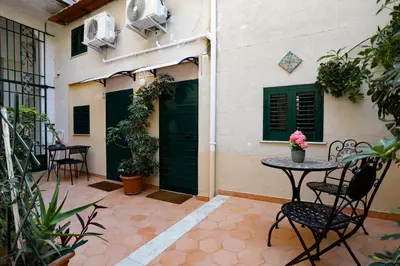 a patio with a table and chairs in front of a building at Bella Sicilia in Palermo