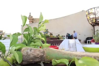 a table with some plants on it with people in the background at Attico in centro città in Alcamo