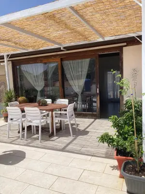 a wooden table and chairs on a patio at Attico in centro città in Alcamo