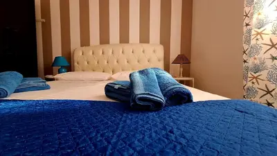 a bedroom with a bed with a blue pod on a table at cico appartamento in San Vito lo Capo