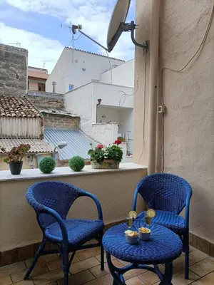 two chairs and a table on a balcony at La Sicilia in casa in Cinisi