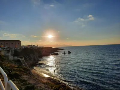a sunset over a body of water with people in boats at La Sicilia in casa in Cinisi