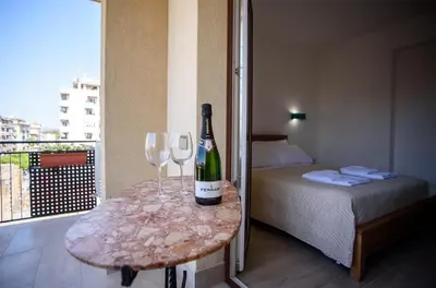 a room with a table with a bottle of wine and two glasses at CENTRAL STATION APARTMENTS - Fanale Rentals in Palermo