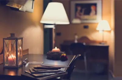 a table with a lamp and a candle on it at Albergo Athenaeum in Palermo