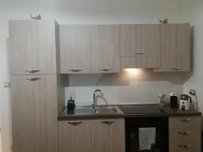 a kitchen with wooden cabinets and a sink at Casa vacanza Sole di Sicilia in Palermo