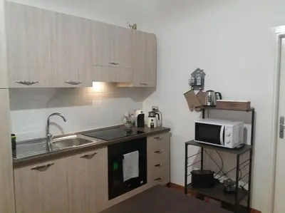 a small kitchen with a sink and a microwave at Casa vacanza Sole di Sicilia in Palermo