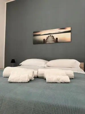 a bedroom with two beds with white towels on the bed at Cusciulìu House in Palermo
