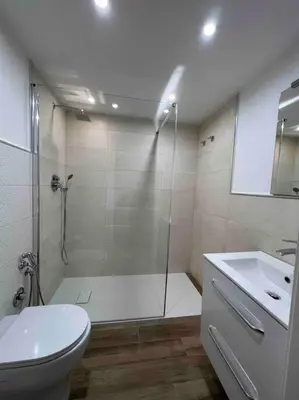 a bathroom with a shower and a toilet and a sink at Cusciulìu House in Palermo
