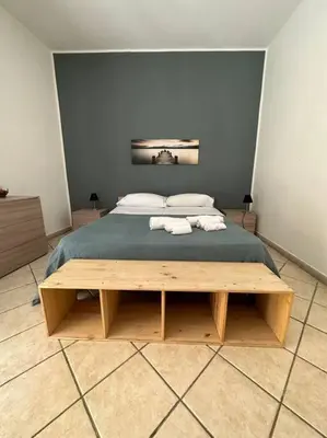a bedroom with a large bed with two towels on it at Cusciulìu House in Palermo